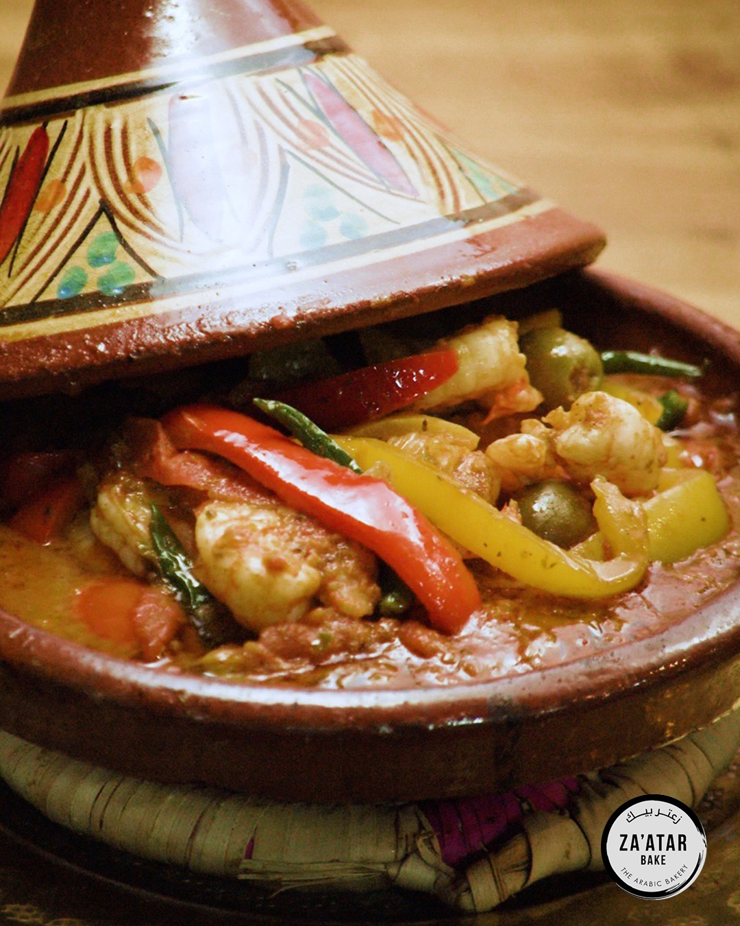 Za'atar Bake seafood tagine cooked with prawns, peppers, and olives in a clay pot